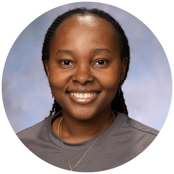 Chi Mutiso's headshot. A young woman with braids wearing a gray t-shirt and a gold necklace. They are smiling at the camera against a light gray-blue background.